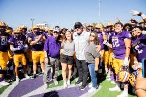 Coach Burleson posing with his family and players